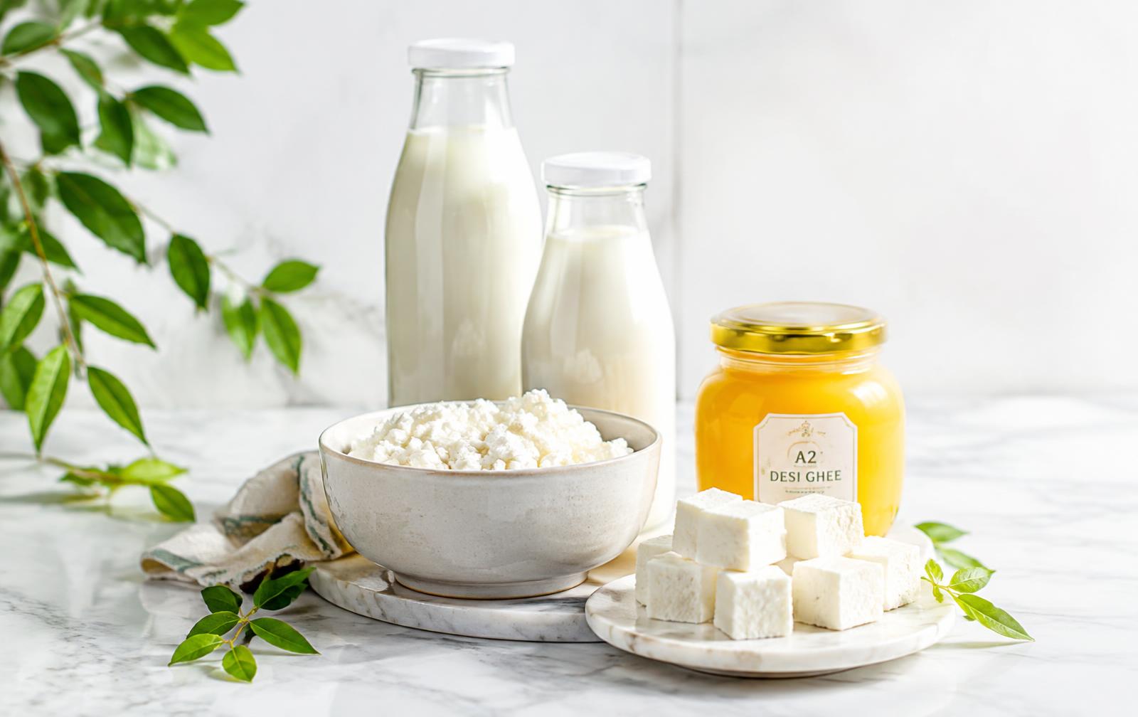 Fresh milk bottles, curd, paneer and ghee on marble